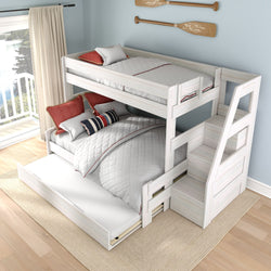 White wooden bunk bed with staircase, pull-out trundle and storage drawers in a coastal-style kids bedroom with white quilted bedding, red accent pillows and nautical oar wall decor overlooking a lake balcony