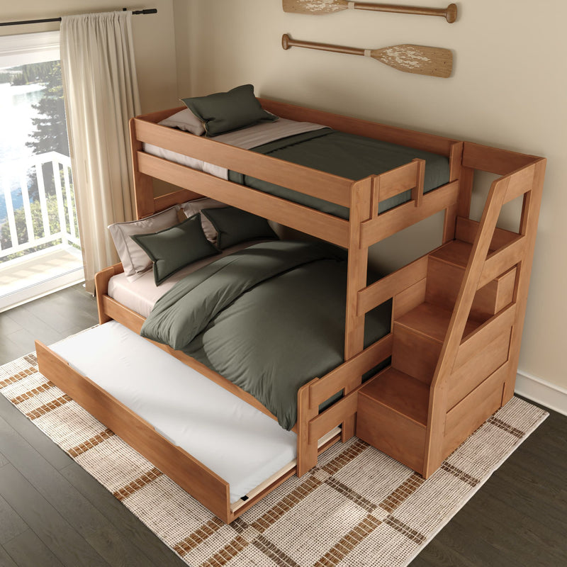 Solid wood bunk bed with integrated staircase and pull-out trundle, styled with olive-green linens and pillows in a sunlit lakeside bedroom with a balcony window and decorative wooden oars on the wall.