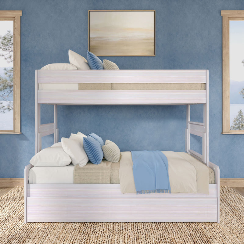 White wooden bunk bed with full-size lower bed, blue accent wall, layered pillows and light-blue throw on woven jute rug in coastal bedroom