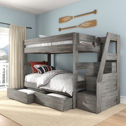 Rustic gray wooden twin-over-full bunk bed with built-in staircase and under-bed storage drawers, white quilted bedding, light blue walls and nautical paddle wall decor