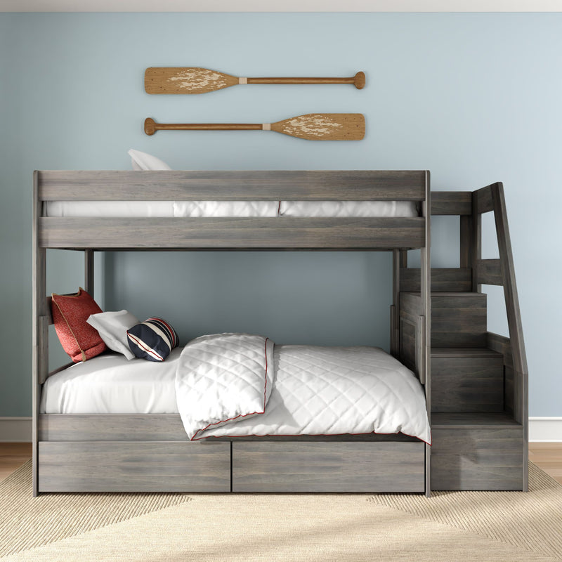 Gray wooden bunk bed with staircase and under-bed storage drawers, white quilted bedding and nautical oar wall decor in light-blue children's bedroom
