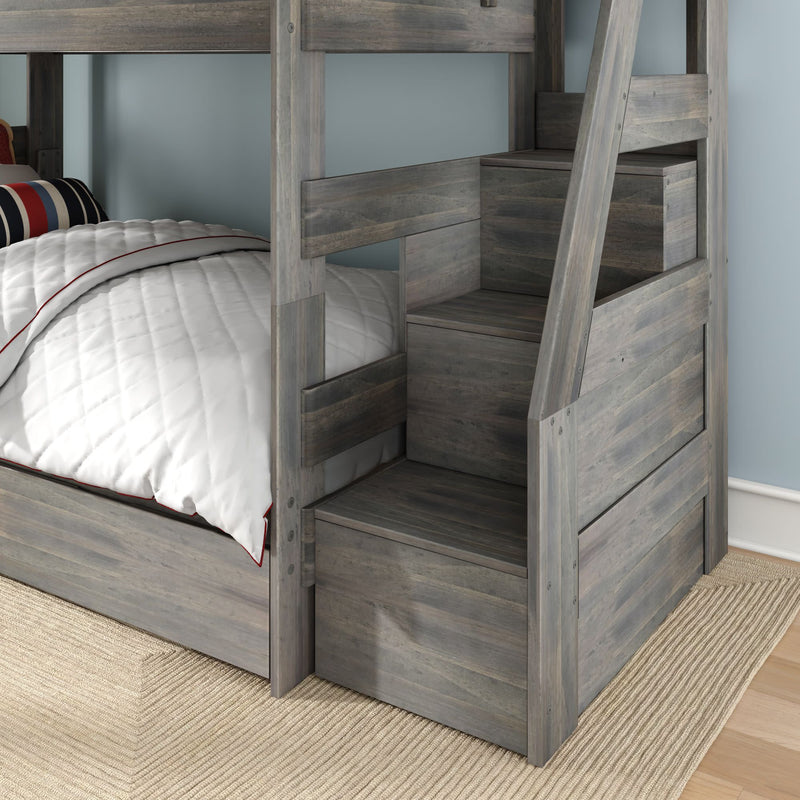Gray wood bunk bed with built-in staircase and under-stair storage drawers, white quilted bedding and striped pillow in a modern kids bedroom