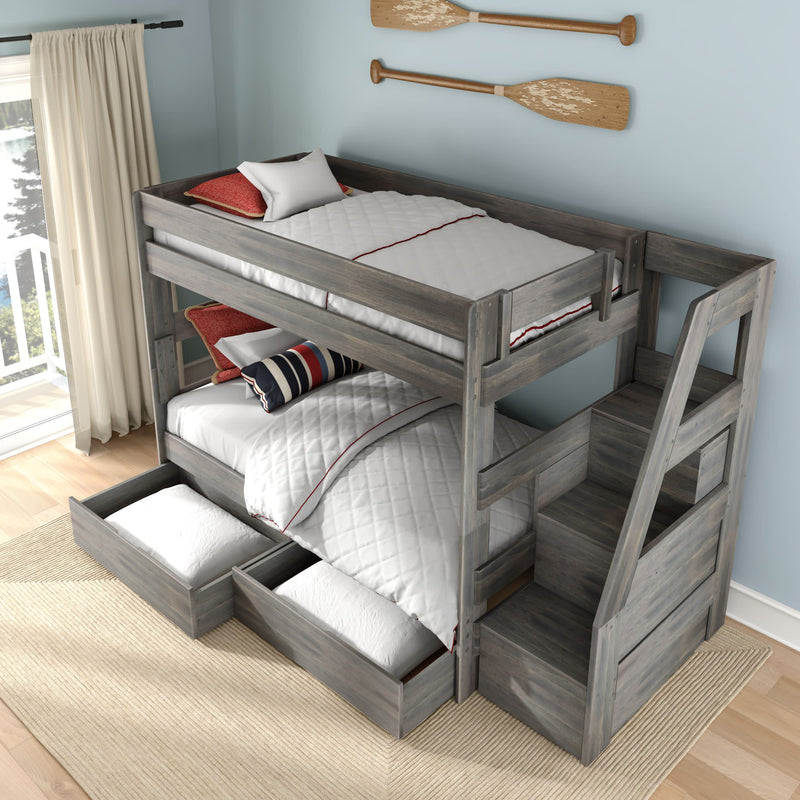 Gray wooden twin-over-full bunk bed with staircase and built-in under-bed storage drawers in a coastal-style bedroom, white quilted bedding with red and navy accent pillows and decorative wooden oars on a light blue wall