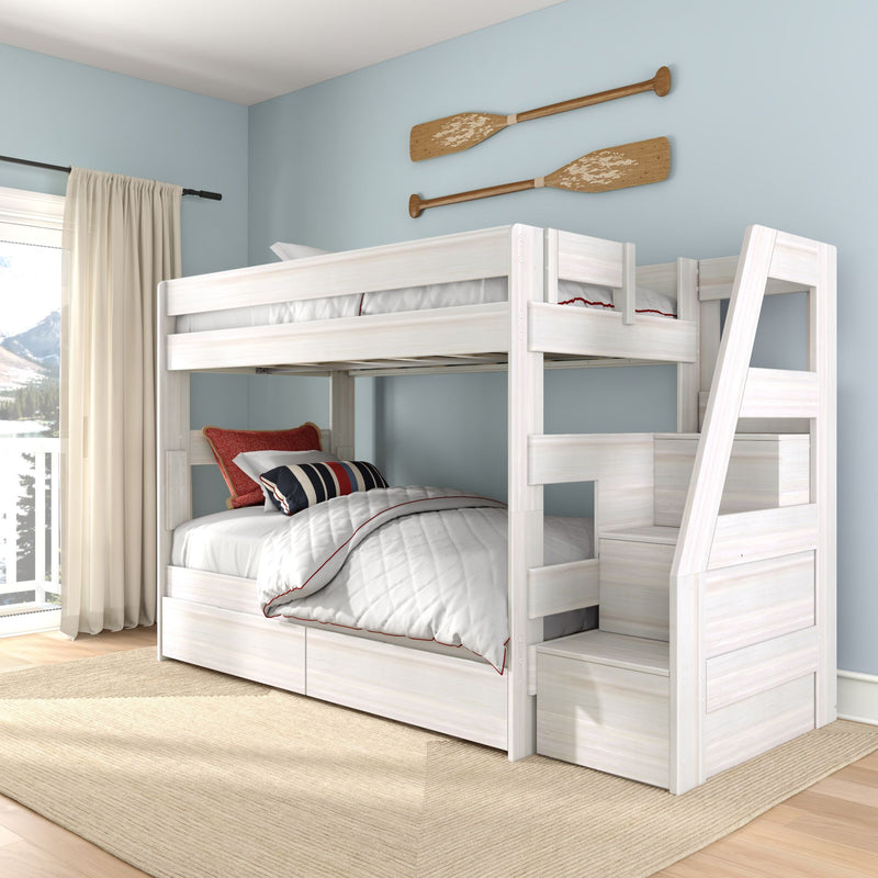White wooden kids bunk bed with storage stairs and drawers, quilted bedding and nautical striped pillows in a coastal blue bedroom with decorative wooden oars wall art