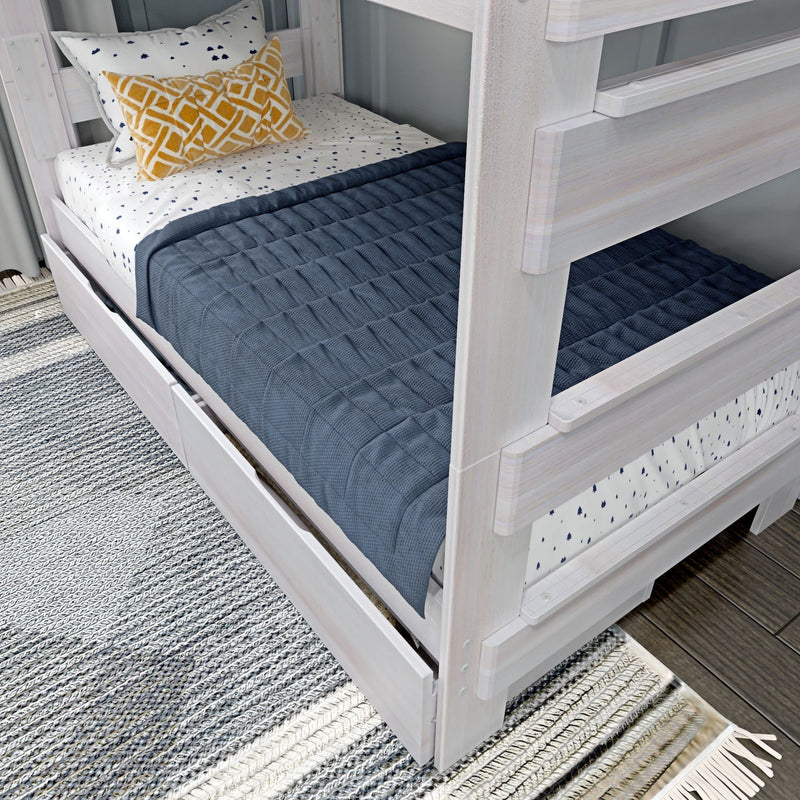 Modern bunk bed with under-bed storage, featuring a navy quilt and decorative pillows, on a cozy area rug.