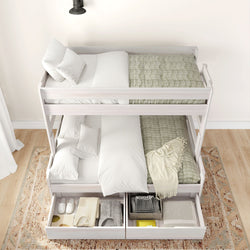 White bunk bed with green quilts and organized storage drawers, modern bedroom furniture.