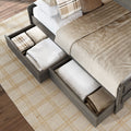 Platform bed with built-in under-bed storage drawers holding folded blankets and pillows on beige plaid rug — space-saving wooden bedroom storage solution