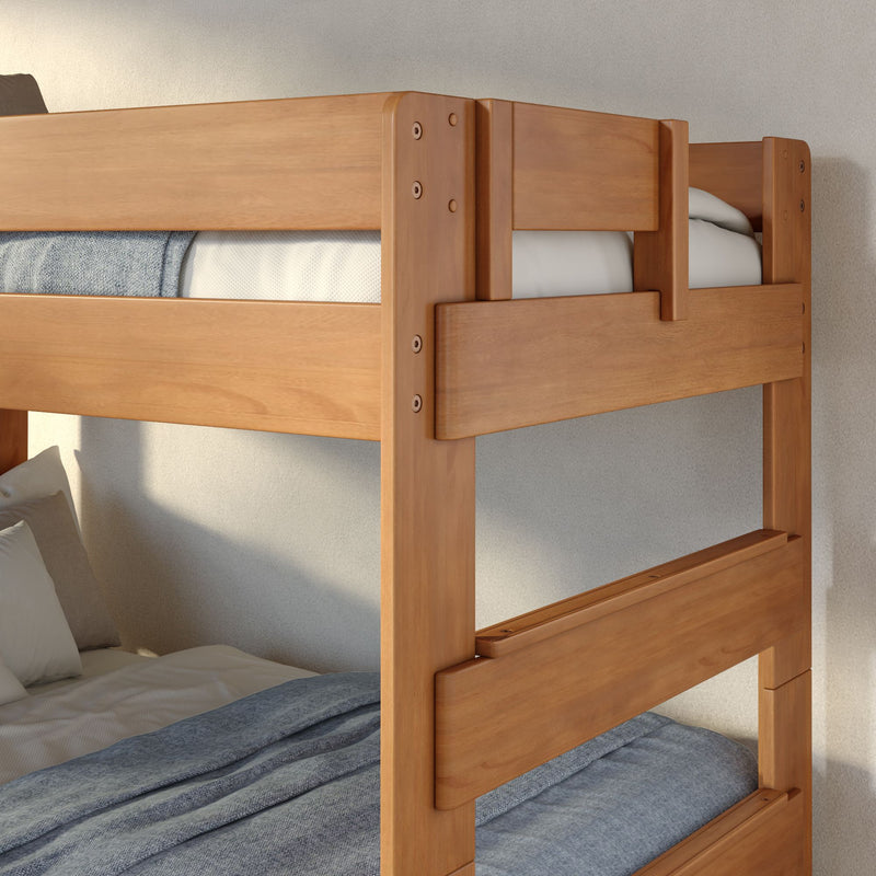 Natural wood bunk bed close-up showing guardrail, mattress, white pillow and gray textured blanket in a modern bedroom