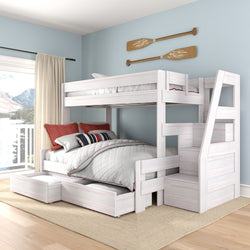 Whitewashed wooden twin-over-full bunk bed with built-in staircase, pull-out storage drawers, nautical oar wall decor, red and striped pillows, and light blue coastal bedroom with large window lake view
