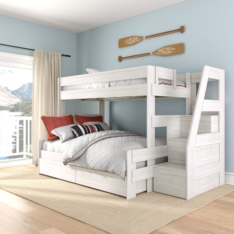 White wooden twin-over-full bunk bed with built-in stairs and storage drawers in a coastal kids' bedroom with blue walls, red pillows and lake-view window
