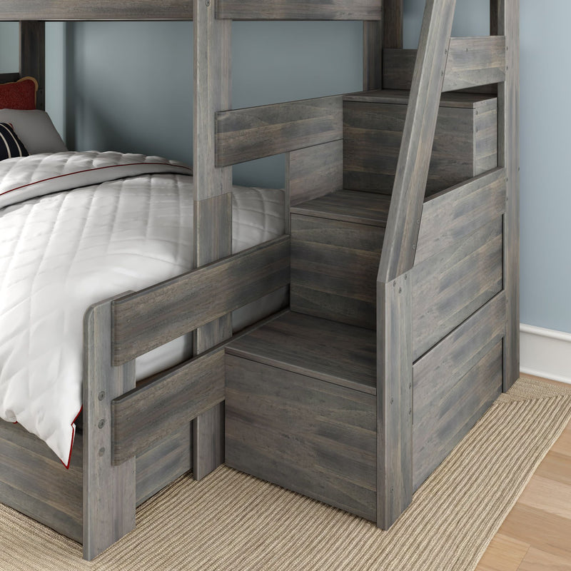 Grey wood bunk bed with integrated stair storage and drawers, white quilted bedding and light blue bedroom wall