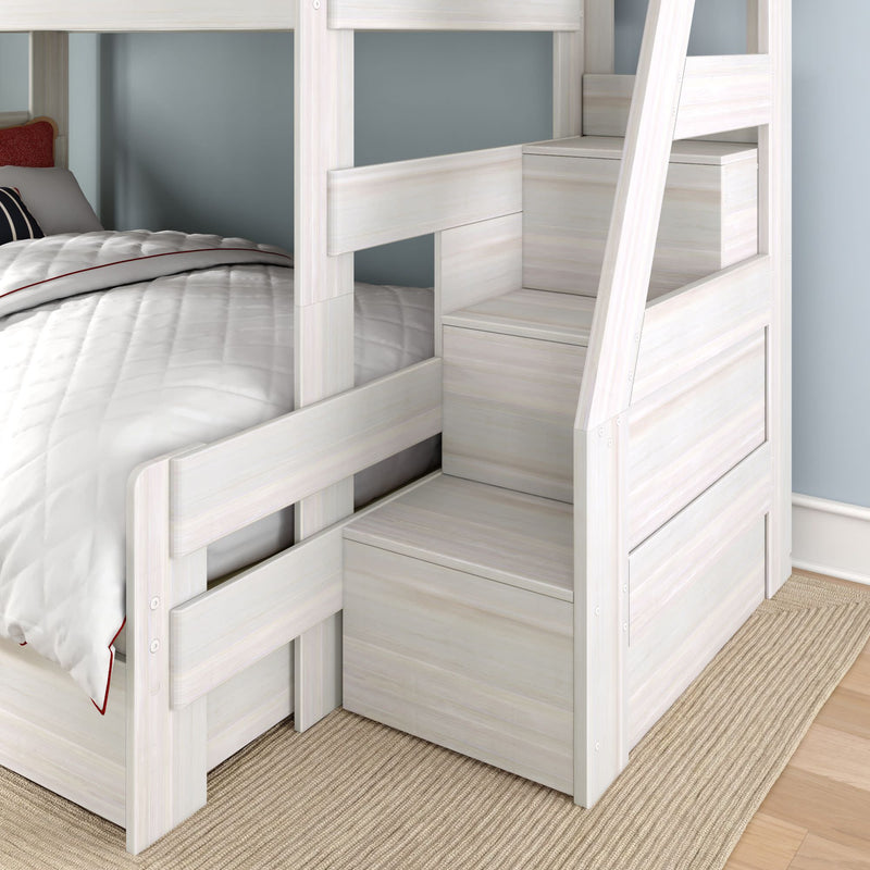 Whitewashed wooden bunk bed with built-in storage staircase and lower twin bed, white quilted bedding and blue wall