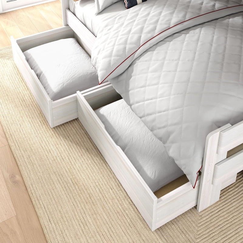 White wooden bed with quilted white bedding and pull-out under-bed storage drawers holding pillows — space-saving bedroom storage solution on light hardwood floor