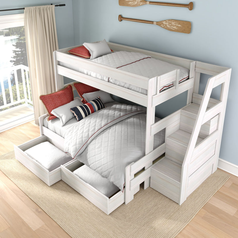 White wooden twin-over-full bunk bed with built-in staircase and storage drawers in coastal kids' bedroom with light blue walls, red and navy pillows and balcony lake view