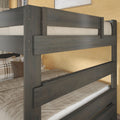 Dark gray wooden bunk bed with sturdy horizontal guardrails, beige bedding and plaid pillows in a cozy warm-tone bedroom