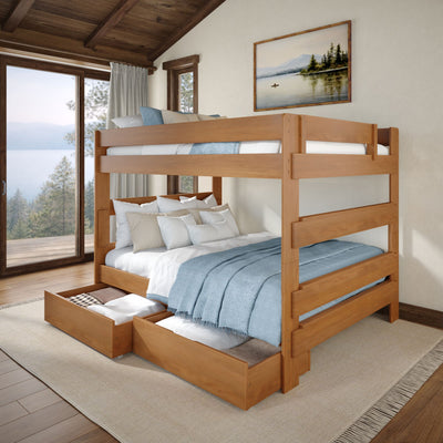 Solid wood bunk bed with under-bed storage drawers, cozy blue linens and large window overlooking a lake in a rustic bedroom