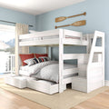 White wooden twin-over-full bunk bed with built-in staircase and pull-out storage drawers in a coastal blue bedroom with nautical oar wall decor and lake view