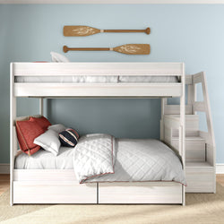 White wooden twin-over-full bunk bed with stairs and storage drawers, nautical pillows and wooden paddles on a light blue wall
