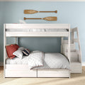 White wooden twin-over-full bunk bed with stairs and storage drawers, nautical pillows and wooden paddles on a light blue wall