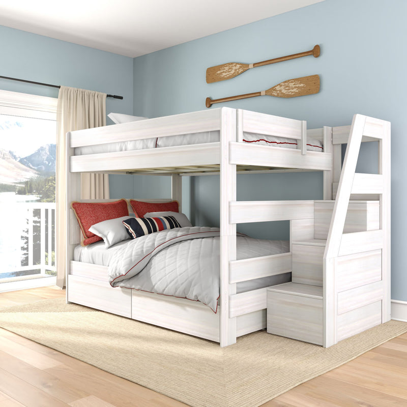 White wooden twin-over-full bunk bed with staircase and built-in storage in coastal blue bedroom with red accent pillows and balcony mountain view