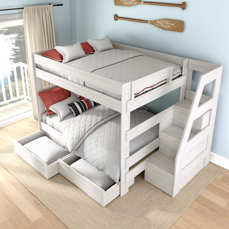White wooden twin-over-twin bunk bed with space-saving built-in staircase and under-bed storage drawers in a coastal-style kids' bedroom with light blue walls, red accent pillows and a lake-view window