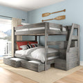 Rustic gray wooden bunk bed with built-in staircase and under-bed storage drawers in a coastal bedroom with light blue walls and decorative oars.
