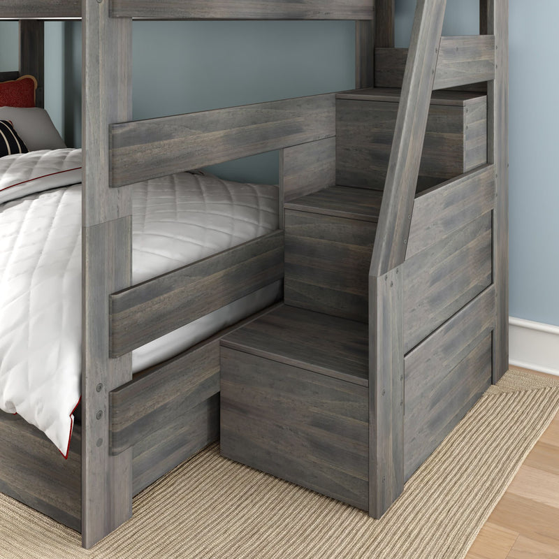 Gray wooden twin-over-full bunk bed with built-in staircase storage drawers, rustic gray finish, white quilted bedding — space-saving kids bedroom furniture on beige rug