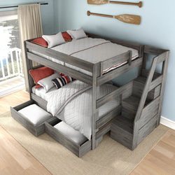 Gray weathered wood bunk bed with built-in staircase and pull-out storage drawers, white quilted bedding and red accent pillows in a coastal bedroom with paddles on the wall and balcony lake view