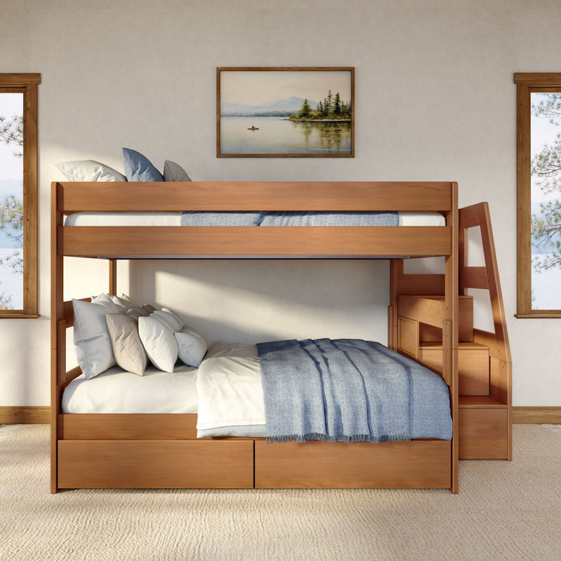 Wooden bunk bed with built-in storage drawers, blue throw blanket and layered pillows in a modern rustic bedroom with framed landscape art and natural light windows