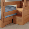 Modern solid wood bunk bed with built-in storage stairs, natural oak finish and blue bedding — space-saving bedroom solution