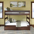 Walnut twin-over-full solid wood bunk bed with under-bed storage drawers, white linens and green accent pillows in a cozy lakeview farmhouse bedroom with framed landscape art