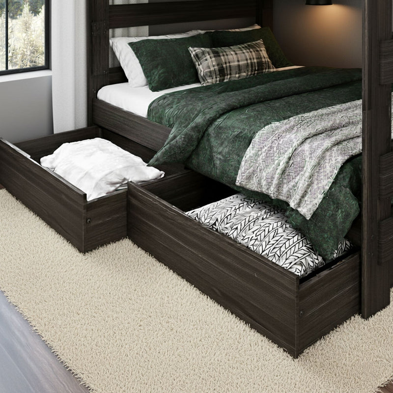 Dark wood platform bed with under-bed storage drawers open showing pillows and linens, green bedding and plaid accent pillow in a modern bedroom
