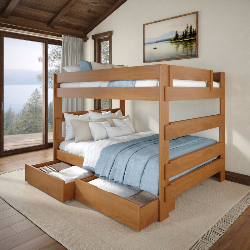 Wooden full-over-twin bunk bed with under-bed storage drawers, blue bedding and pillows in a cozy lake-view cabin bedroom with large windows