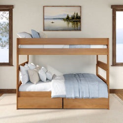 Solid wood twin-over-full bunk bed with under-bed storage drawers, light blue bedding and multiple pillows in a cozy lake-view bedroom with framed landscape art