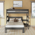 Gray twin-over-full bunk bed with ladder in modern farmhouse bedroom, rustic gray wood frame, neutral beige bedding and plaid pillows, space-saving design between two windows with tree views