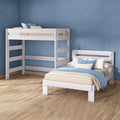 Whitewashed wooden loft bunk bed and single bed in modern blue bedroom with hardwood floor, beige bedding and blue pillows
