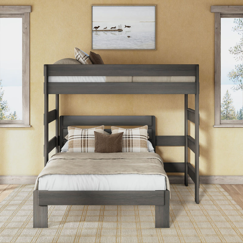 Twin-over-full bunk bed in gray wood finish with ladder and guardrail, full lower bed dressed in neutral linens and plaid pillows in a sunlit modern rustic bedroom