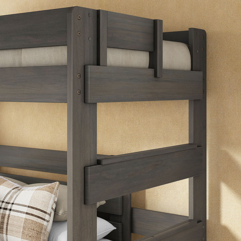 Dark gray solid wood twin-over-twin bunk bed with safety rails and plaid pillow in cozy beige bedroom