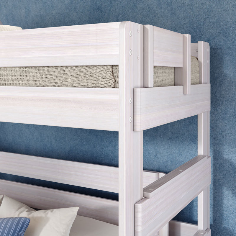Whitewashed twin-over-twin bunk bed with safety rails and knit mattress against blue textured wall