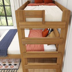 Wooden bunk bed with colorful bedding and pillows in a sunlit bedroom.