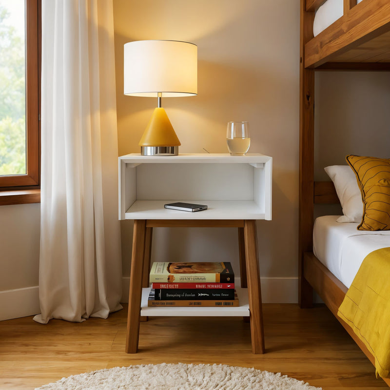 Modern bedroom with a stylish white nightstand featuring a book stack, table lamp, smartphone, and glass of water.