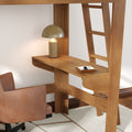 Solid wood loft bed with integrated desk and ladder, metal dome table lamp, leather swivel chair and accessory tray in a compact home office