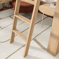 Light natural wood ladder on beige geometric rug in modern Scandinavian bedroom with round wood side table and brown velvet chair