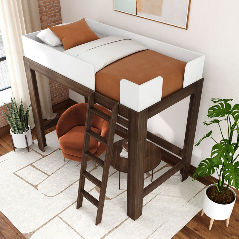 Modern wooden loft bed with white guardrails and ladder, brown bedding and orange lounge chair beneath with round table, neutral rug and potted plants in a compact contemporary bedroom