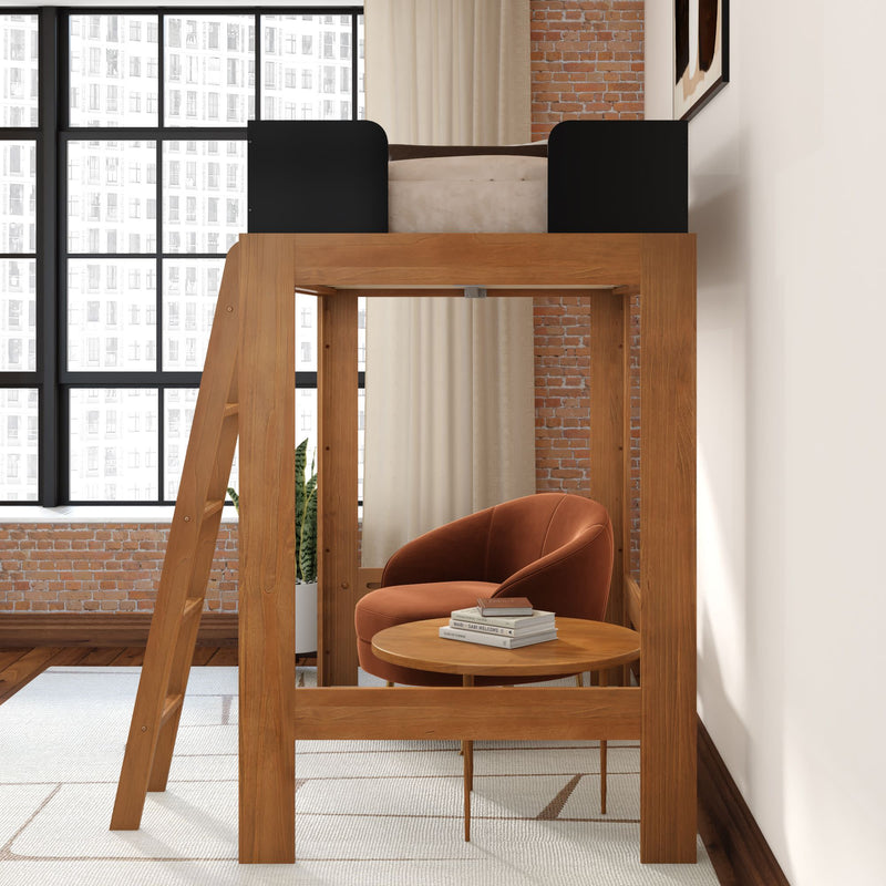 Modern wooden loft bed with ladder and cozy reading nook underneath featuring an orange velvet armchair, round wooden side table with books, exposed brick wall and large industrial grid windows
