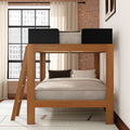 Modern wooden loft bunk bed with ladder, neutral bedding, exposed brick wall and large industrial-style window in a cozy urban loft bedroom
