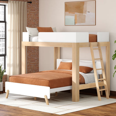 Modern natural wood loft-style twin-over-full bunk bed with ladder and white guardrails, rust-orange bedding, space-saving kids or guest bedroom solution against an exposed brick wall with large window and potted plant