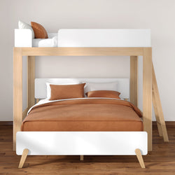 Modern wooden bunk bed with double lower bed and single upper bed, brown duvet and pillows, white headboards and ladder in a minimalist Scandinavian bedroom on hardwood floor