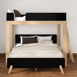 Modern solid wood full-over-twin bunk bed with black accents, ladder and neutral beige bedding in contemporary bedroom