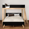 Modern light-wood twin-over-full bunk bed with black headboards and ladder, neutral beige bedding and brown accent pillows on hardwood floor — space-saving kids or guest bedroom furniture